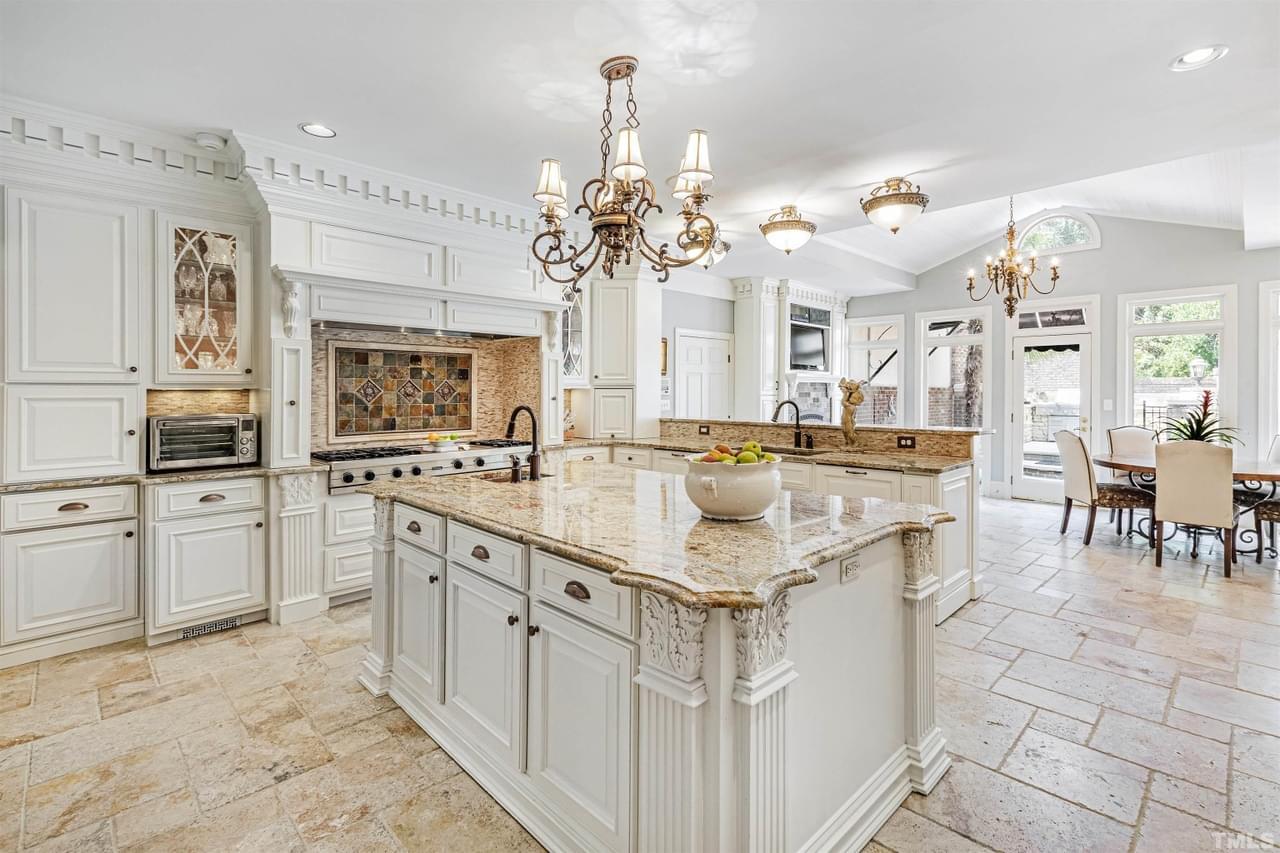 An ornate, luxury kitchen in white, cream, and beige tones with clear attention to detail